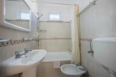 a bathroom with a sink and a toilet and a mirror at Villas Brites nº2 in Burgau