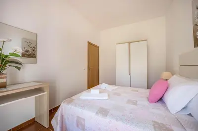 a bedroom with a bed with a pink pillow at Villas Brites nº2 in Burgau