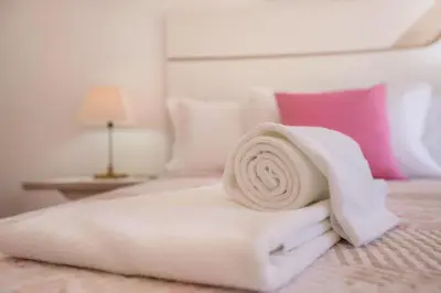 a pile of white towels on a bed at Villas Brites nº2 in Burgau