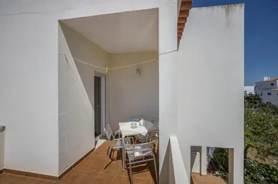 a room with a table and chairs on a balcony at Villas Brites nº3 in Burgau