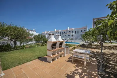 a gazebo and a bench in front of a building at Villas Brites nº3 in Burgau