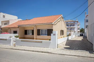 a kitchen with wooden cabinets and a table and a counter top at Casa Fernandes in Burgau
