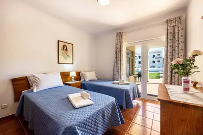 a hotel room with two beds and a balcony at Villas Brites nº1 in Burgau