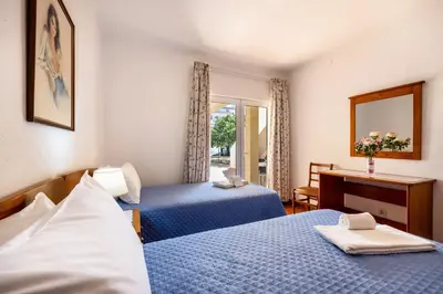 a hotel room with two beds and a desk at Villas Brites nº1 in Burgau