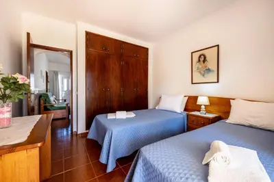 a hotel room with two beds and a mirror at Villas Brites nº1 in Burgau