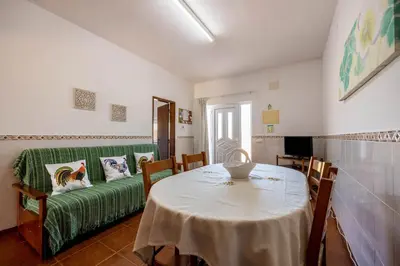 a living room with a table and a green couch at Villas Brites nº1 in Burgau