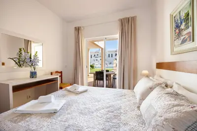 a bedroom with a bed with a desk and a window at Villas Brites nº1 in Burgau