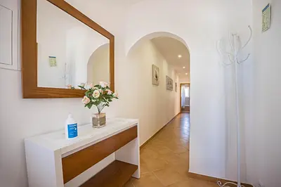 a bathroom with a mirror and a sink with flowers at Casa Bege T2 in Burgau
