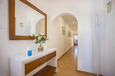 a white bedroom with a large bed and two tables at Casa Bege T2 in Burgau