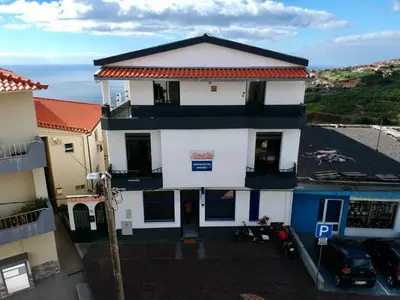 an aerial view of a house with the ocean in the background at Mountain View Star in Estreito da Calheta