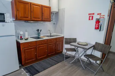a kitchen with a sink and a table with chairs at Mountain View Star in Estreito da Calheta