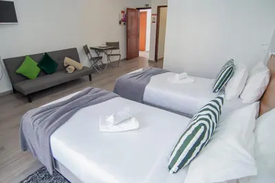 a hotel room with two beds and a couch at Mountain View Star in Estreito da Calheta