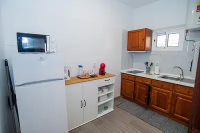 a kitchen with a white refrigerator and wooden cabinets at Mountain View Star in Estreito da Calheta