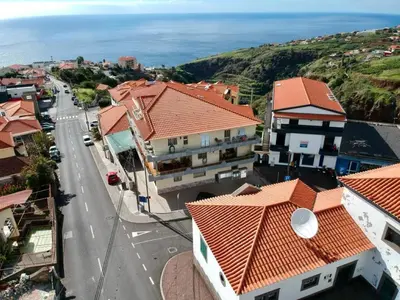 an aerial view of a town with houses and the ocean at Mountain View Star in Estreito da Calheta