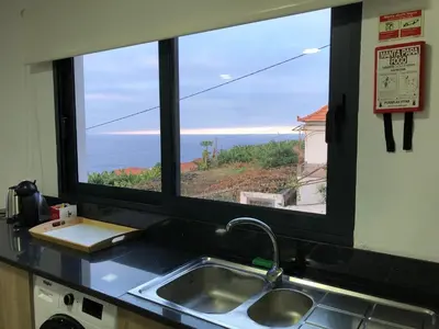a kitchen sink and a window with a view of the ocean at Calheta Ocean View Family Apartment - Air Condition in Estreito da Calheta