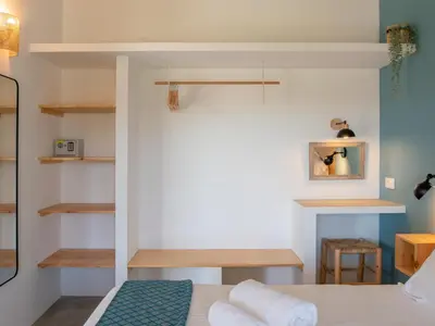 a bedroom with a bed and shelves in it at Ao Sabor do Vento (+12 ) in Aljezur