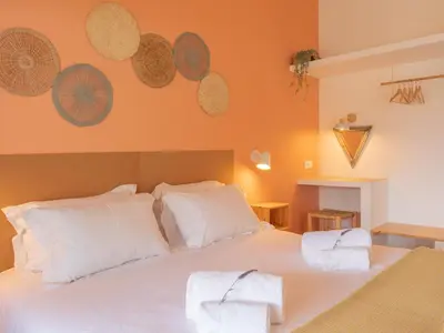 a bedroom with a large white bed with white pillows at Ao Sabor do Vento (+12 ) in Aljezur
