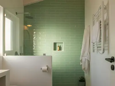 a bathroom with green subway tiles and a white refrigerator at Ao Sabor do Vento (+12 ) in Aljezur