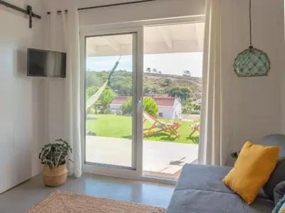 a living room with a sliding glass door to a patio at Ao Sabor do Vento (+12 ) in Aljezur