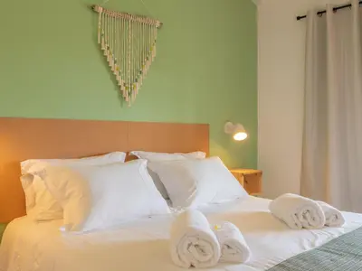 a bedroom with a bed with towels on it at Ao Sabor do Vento (+12 ) in Aljezur