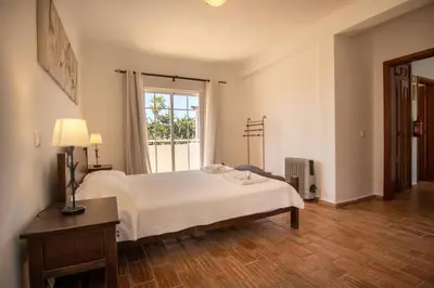 a bedroom with a white bed and a window at Villa Carraig in Luz