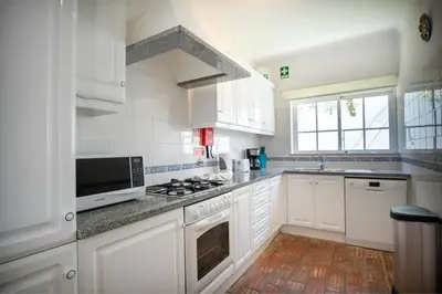 a kitchen with white cabinets and a stove top oven at Villa Carraig in Luz