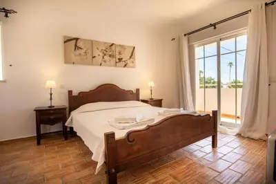a bedroom with a bed and a large window at Villa Carraig in Luz