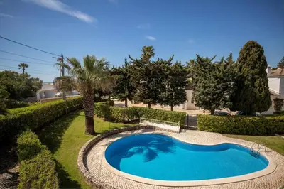 a swimming pool in a yard with trees and bushes at Villa Carraig in Luz