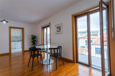 a dining room with a table and chairs and large windows at FLH Funchal Studio with Balcony in Funchal