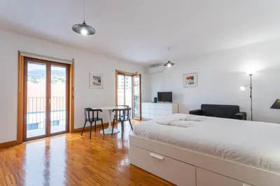 a bedroom with a bed and a table and chairs at FLH Funchal Studio with Balcony in Funchal