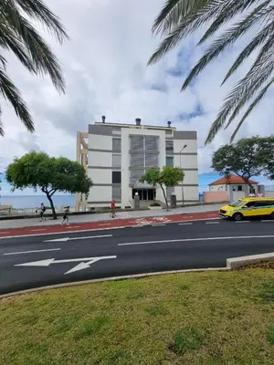 a building on the side of a street with a yellow taxi at Magical Seaview (Free Parking) in Funchal