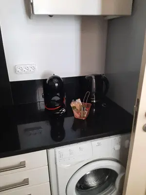 a kitchen with a washing machine and a black counter top at Magical Seaview (Free Parking) in Funchal