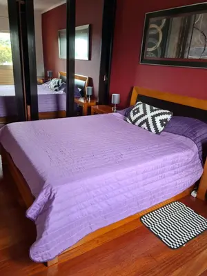 a bedroom with a large bed with a purple comforter at Machico Beach Comfort in Machico