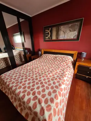a bedroom with a bed and a red wall at Machico Beach Comfort in Machico