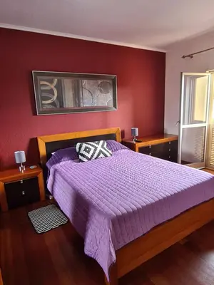 a bedroom with a bed with a purple comforter at Machico Beach Comfort in Machico