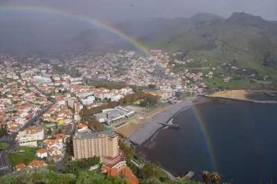 an aerial view of a city with a rainbow at Machico Beach Comfort in Machico