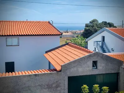 a white house with an orange roof and a garage at Porto Santo Casa Dourada in Porto Santo