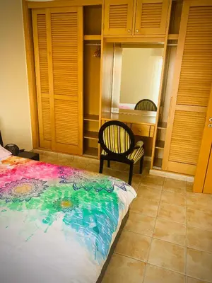a bedroom with a bed and a chair and a mirror at Porto Santo Casa Dourada in Porto Santo