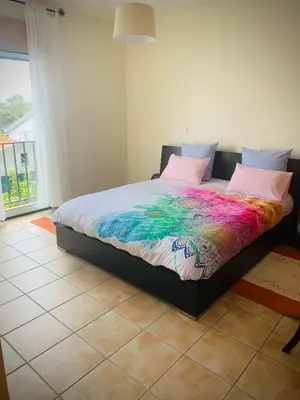 a bedroom with a bed with a colorful blanket on it at Porto Santo Casa Dourada in Porto Santo