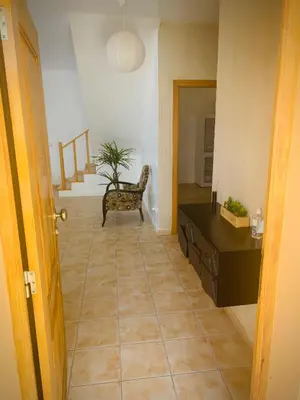a hallway with a table and a chair in a room at Porto Santo Casa Dourada in Porto Santo