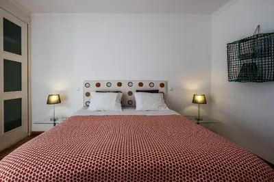 a bedroom with a large red bed with two lamps at Beach Park Apartments in Luz