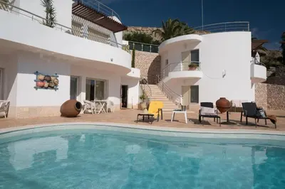 a villa with a swimming pool in front of a house at Beach Park Apartments in Luz