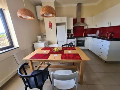 a kitchen with a wooden table and chairs at Funchal Centre Comfort in Funchal