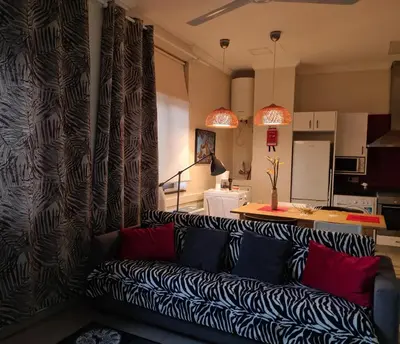 a living room with a couch and a kitchen at Funchal Centre Comfort in Funchal