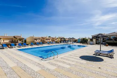 a pool at a resort with lounge chairs at Casa Ocean Golf - Boavista Resort in Lagos
