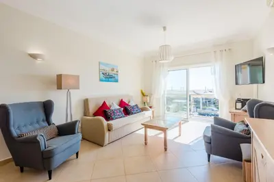 a living room with a couch and chairs and a tv at Casa Ocean Golf - Boavista Resort in Lagos