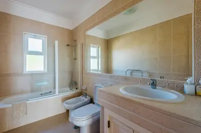 a bathroom with a sink and a toilet and a tub at Casa Ocean Golf - Boavista Resort in Lagos