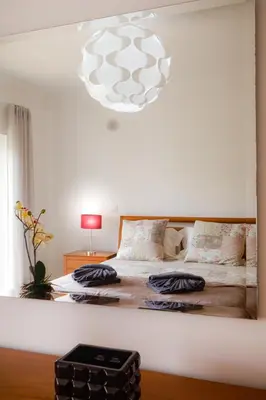 a bedroom with a large bed with a chandelier at Lagos beach condo in Lagos