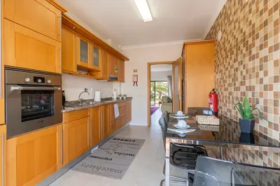 a kitchen with wooden cabinets and a counter top at Lagos beach condo in Lagos
