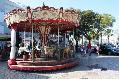 a carousel on a city street with people on it at Lagos beach condo in Lagos